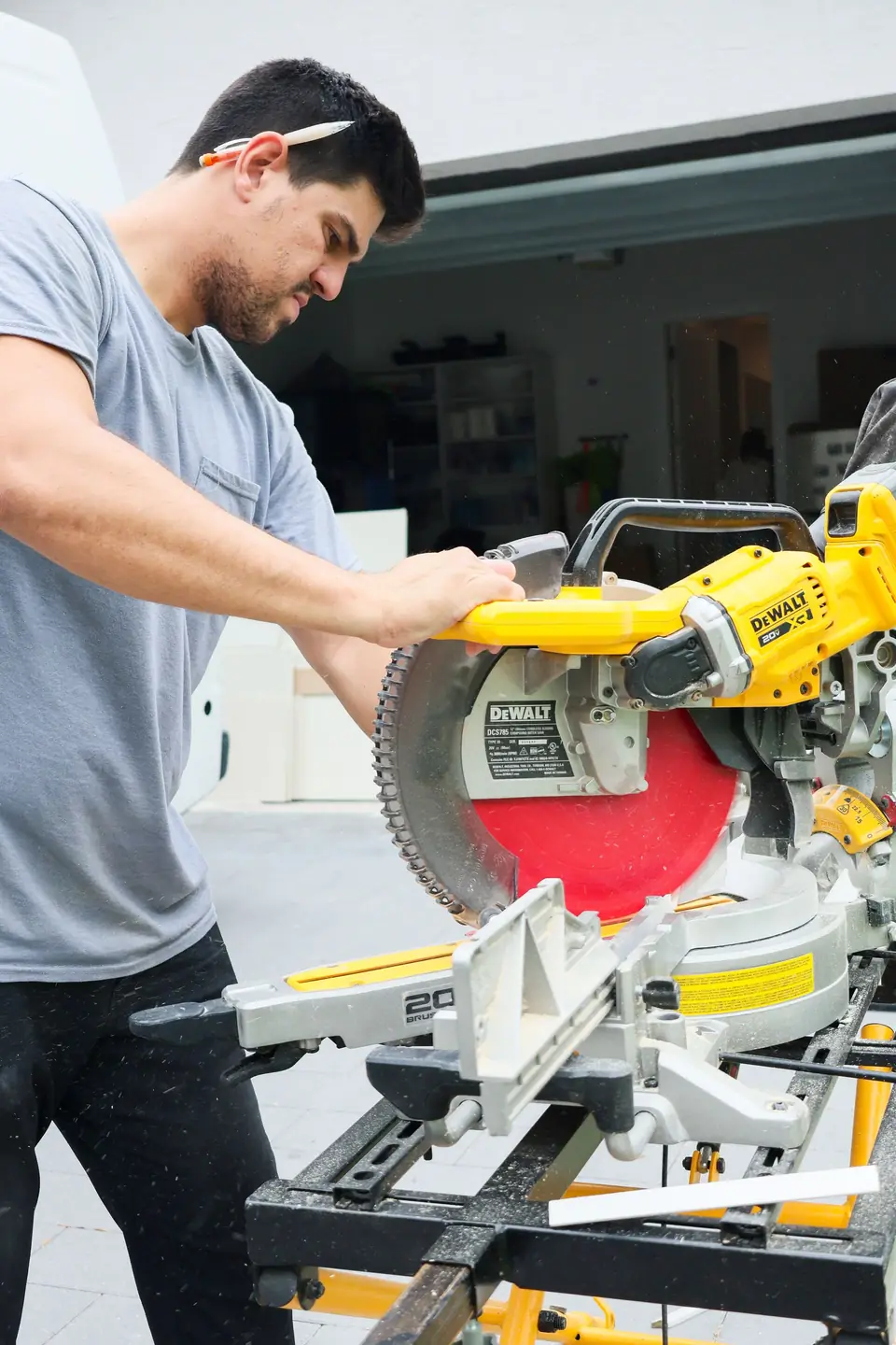 Carpentry Squad carpenter cutting trim on a miter saw