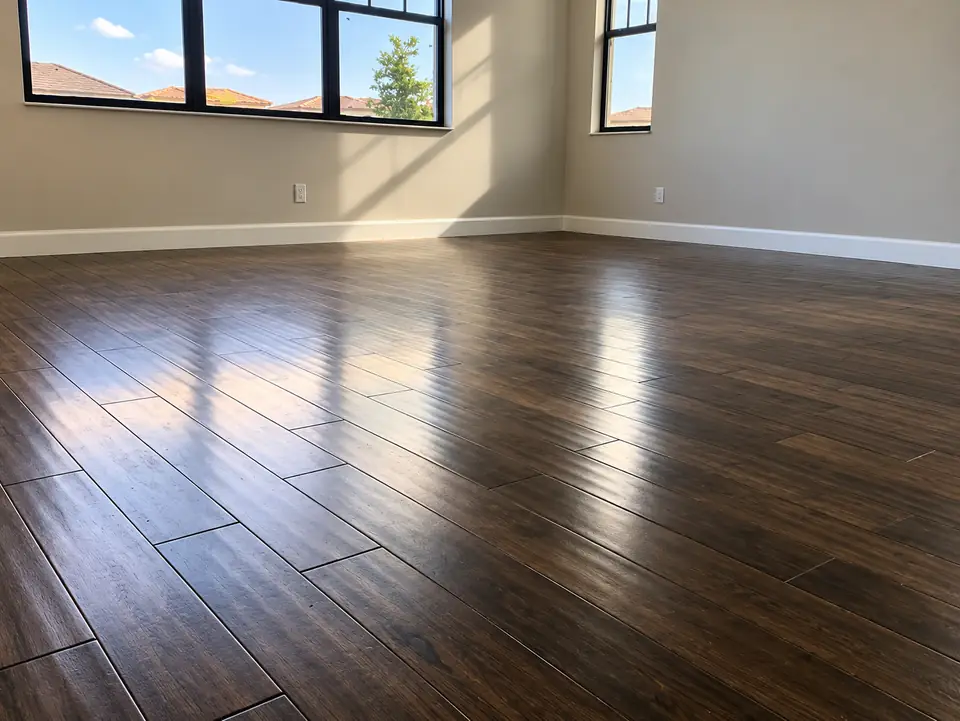 Dark wood plank flooring installed across an open room with large windows