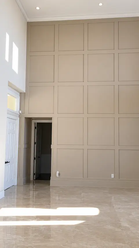 Tall grid-paneled feature wall in a double-height foyer